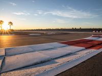 a photo of a dirt race track with sun setting in the distance of the track