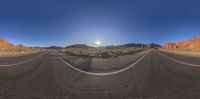 an empty road in the middle of desert area and rocky landscape near mountains with rocks