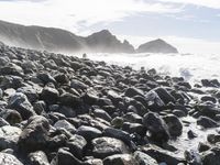 rocks line the shore and ocean on a sunny day to be used as a backdrop or wallpaper