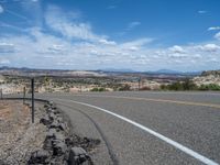 USA's Rural Road: Red Rock Formations and Fluffy Clouds