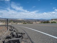 USA's Rural Road: Red Rock Formations and Fluffy Clouds