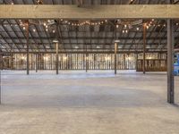 the empty warehouse with lights on the ceiling and a floor with cement floors under it