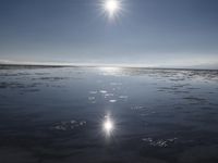 the sun is shining brightly over the horizon of the water's surface as it reflects the sky