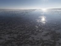 the sun is shining brightly over the horizon of the water's surface as it reflects the sky