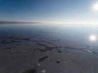 the sun is shining brightly over the horizon of the water's surface as it reflects the sky