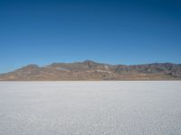 a view of the desert landscape with mountains in the background and snow on the ground