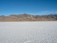 a view of the desert landscape with mountains in the background and snow on the ground