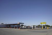 a gas station is empty with truck parked in the lot near it and a sign that reads,