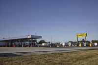 a gas station is empty with truck parked in the lot near it and a sign that reads,