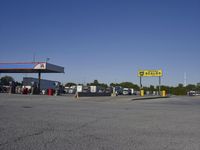 a gas station is empty with truck parked in the lot near it and a sign that reads,