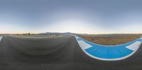 the view of an asphalt track from outside the camera lens on a sunny day with blue sky and mountains in the background