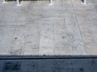 a concrete skateboarder performs the trick in front of an empty ramp during the day