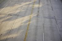 an overhead view looking down at a yellow line on a street in an empty city