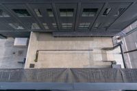 the view looking down at a sidewalk and building from a top down platform in a large area