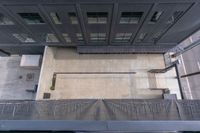 the view looking down at a sidewalk and building from a top down platform in a large area