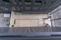 the view looking down at a sidewalk and building from a top down platform in a large area