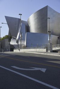 an empty street near a cityscape and futuristic buildings with advertisements on the side of the buildings