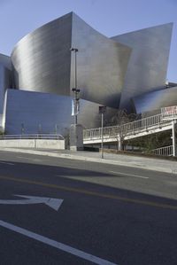 an empty street near a cityscape and futuristic buildings with advertisements on the side of the buildings