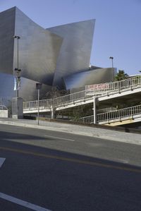 an empty street near a cityscape and futuristic buildings with advertisements on the side of the buildings