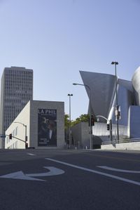 an empty street near a cityscape and futuristic buildings with advertisements on the side of the buildings