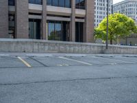 a street with a building near the building in the middle and on the left of which is a parking lot, as shown in this photo