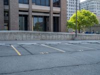 a street with a building near the building in the middle and on the left of which is a parking lot, as shown in this photo