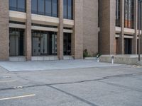 a street with a building near the building in the middle and on the left of which is a parking lot, as shown in this photo