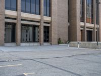 a street with a building near the building in the middle and on the left of which is a parking lot, as shown in this photo