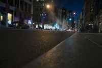 a street with cars parked at an intersection, on a busy night time in a city