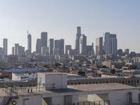 a city view with lots of tall buildings and stairs up to them, seen from the rooftop of the building