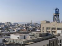 a city view with lots of tall buildings and stairs up to them, seen from the rooftop of the building