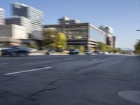 a blurred photo of cars, buildings and a street light in an urban area of the city