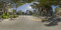 a city street with several trees and buildings in front of it taken through an intersection