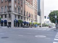 an empty street with several vehicles at the crosswalk and a light post and a building