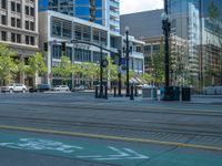 an empty street with buildings and parked cars on the sidewalks and green lanes on the sidewalk