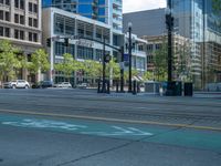 an empty street with buildings and parked cars on the sidewalks and green lanes on the sidewalk