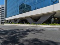 empty sidewalk next to large building in urban area of city scene with building in reflection