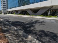 empty sidewalk next to large building in urban area of city scene with building in reflection