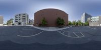 a 360 - spherical view of a street intersection with a building and cars in the background