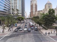 an intersection with multiple traffic lines on both sides of a street, with cars driving through the center and palm trees lining both sides