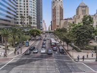 an intersection with multiple traffic lines on both sides of a street, with cars driving through the center and palm trees lining both sides