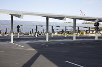 a parking lot with rows of solar panels on top and a sky line in the background