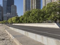 empty road with several trees on both sides and large buildings in the distance, downtown skyline