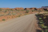 a dirt road is going through the desert in a mountainous area, with rocky terrain