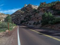 a single - lane road winds up to a mountain side, in the united states