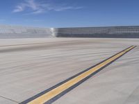 an airport has a large field and lots of buildings in the background it has yellow lines that mean,