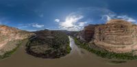 a panoramic photograph of the colorado river and cliffs above it in a valley