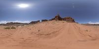 a dirt road in a desert area with many dirt tracks on it and a small cliff