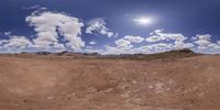 an empty desert with hills and clouds in the sky is reflected in a fish - eye lens