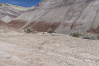 the large dirt field near a mountain is brown and sparse as it sits in the desert